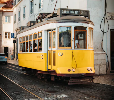 A yellow tram on a historic Lisbon street